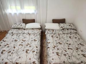 two beds sitting next to each other in a bedroom at Studio Apartman Oaza Nevesinje in Šehovina
