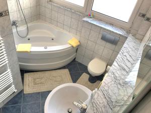 a bathroom with a tub and a toilet and a sink at Apartments Ilidža in Sarajevo
