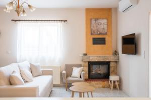 a living room with a white couch and a fireplace at Ifigenia sea view in Artemida