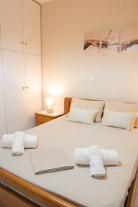 a bedroom with a white bed with towels on it at Ifigenia sea view in Artemida