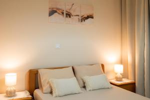 a bedroom with a bed with two lamps on two tables at Ifigenia sea view in Artemida