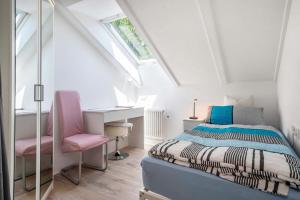 a bedroom with a bed and a pink chair at Fewo Siebert 