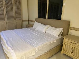 ein Bett mit weißen Laken und Kissen in einem Schlafzimmer in der Unterkunft Water Front Luxury in Jnah Beirut 