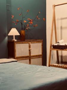 a bedroom with a bed and a vase with a plant at Khế Homestay in Can Tho