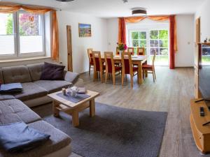 Una sala de estar con un sofá, una mesa y sillas. en Ferienhaus Big Family, en Ellrich