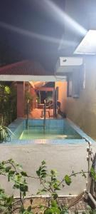 a swimming pool in front of a house at Ashirwad Home Stay , Rustic , 2 bedroom Villa amidst peacocks in Madurai