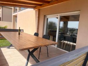 a wooden table with a bottle of wine on a patio at Villa Lavanda in Vodnjan