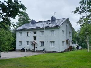 a large white house with a gambrel roof at Aittamajotus casinonsaari in Savonlinna