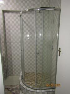 a shower with a glass door in a bathroom at The PHOMOLONG GUEST HOUSE in Roodepoort