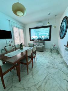 a living room with a table and a tv on the wall at Villa Erika in Gallipoli