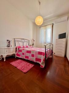 a bedroom with a bed with a red and white blanket at Villa Erika in Gallipoli
