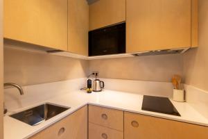 a kitchen with a sink and a microwave at Decô Apartments Barcelona-Born St. in Barcelona +37 photos