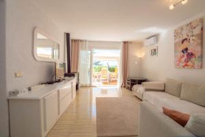 a white living room with a couch and a table at Villa Montemar in Tossa de Mar