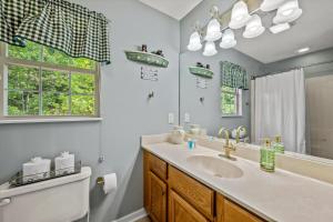 a bathroom with a sink and a toilet and a mirror at Mountains 4 Miles By Avada Properties in Gatlinburg +67 photos