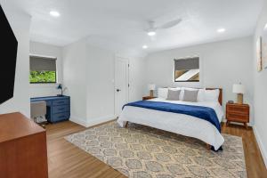 a white bedroom with a bed and a blue blanket at Jalsa in Wimberley +39 photos