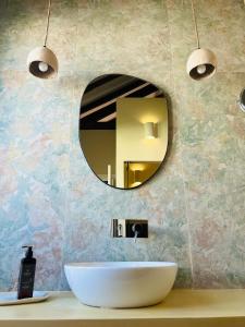 a bathroom with a white sink and a mirror at Oryza Guest House& Suites in Coimbra