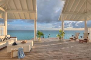 a wooden deck with a view of the ocean at Diamonds Athuruga Maldives Resort & Spa in Athuruga Island