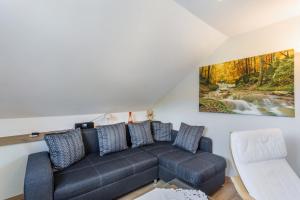 ein Wohnzimmer mit einer Couch und einem Gemälde an der Wand in der Unterkunft Ferienwohnung Am Waldrand in Schmallenberg