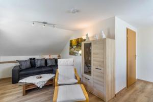 ein Wohnzimmer mit einer Couch und einem Sessel in der Unterkunft Ferienwohnung Am Waldrand in Schmallenberg