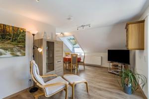ein Wohnzimmer mit einem Stuhl und einem Tisch in der Unterkunft Ferienwohnung Am Waldrand in Schmallenberg