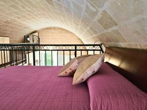 een bed met roze lakens en kussens in een kamer bij La Suite Delle Stelle in Matera