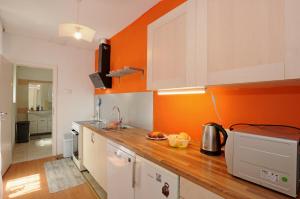 a kitchen with orange walls and a wooden counter top at HOLIDAY's HOUSE in Semedela