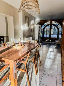 a dining room with a wooden table and chairs at L'échappée aux cerfs SPA in Les Rouges-Eaux
