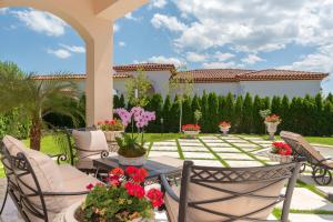 a patio with chairs and a table with flowers at Villa Dolce Vita in Sunny Beach