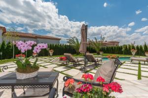 a patio with a table and chairs and flowers at Villa Dolce Vita in Sunny Beach
