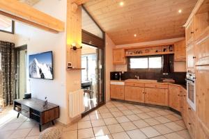 a large kitchen with wooden cabinets and a large window at Superbe Appartement Deux Alpes Cosy et chaleureux 6 personnes in Les Deux Alpes +18 photos