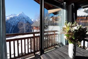 a vase of flowers on a balcony with a view at Superbe Appartement Deux Alpes Cosy et chaleureux 6 personnes in Les Deux Alpes