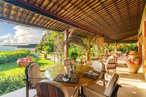 a patio with a table and chairs and the ocean at Hotel Ponta do Madeiro in Pipa