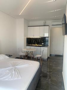 a bedroom with a bed and a table and a kitchen at LISI apartments in Lezhë
