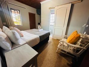 东伦敦Aruwaa的一间卧室，有两张床、一张桌子和一张椅子