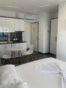 a bedroom with a white bed and a table and chairs at LISI apartments in Lezhë