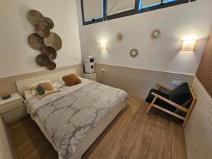 ein Schlafzimmer mit einem Bett und einem Stuhl darin in der Unterkunft Las Artes Hlius Luxury Apartments in Valencia