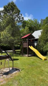 a playground with a slide and a gazebo at Aizpuri Rose View in Nīca
