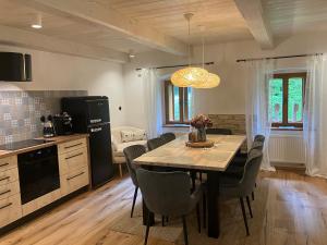 uma cozinha e sala de jantar com mesa e cadeiras em Chalupa Rybná em Hradisko