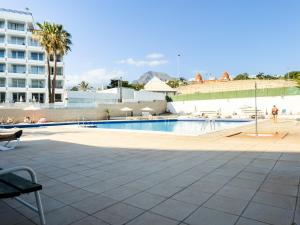 a swimming pool in a resort with a building at Piso los Agaves in Costa de Adeje