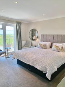 a bedroom with a large bed with a large window at Springwood Room Only Accommodation in Seahouses