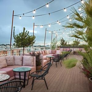 a patio with couches and tables and lights at NH Collection Madrid Suecia in Madrid