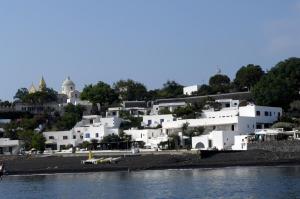a group of white buildings on a hill next to the water at La Sirenetta Park Hotel in Stromboli