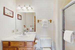 a bathroom with a sink and a toilet and a mirror at Jay Peak Townhouse in Jay +35 photos