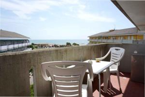 dwa białe krzesła i stół na balkonie w obiekcie Apartment in Porto Santa Margherita 42874 w mieście Porto Santa Margherita di Caorle +3 zdjęcia