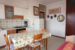 kuchnia ze stołem i białą lodówką w obiekcie Apartment in Porto Santa Margherita 42874 w mieście Porto Santa Margherita di Caorle