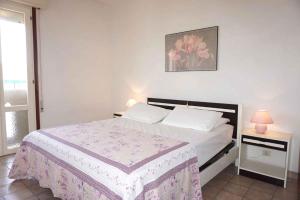 sypialnia z białym łóżkiem i różowym kocem w obiekcie Apartment in Porto Santa Margherita 42874 w mieście Porto Santa Margherita di Caorle