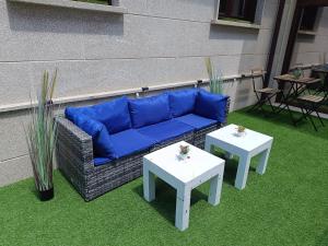 a blue couch and two tables on a patio at A Escola in Moaña