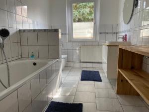 Un baño blanco con bañera y lavabo. en Ferienhaus Big Family, en Ellrich 30 fotos más