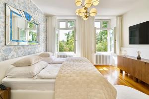 ein Wohnzimmer mit einem weißen Sofa und Fenstern in der Unterkunft Boutique Suites and Residences Heidelberg- Alte Zigarrenmanufaktur in Heidelberg