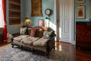 a living room with a couch and a clock on the wall at Vintage Balcony Guesthouse & Suites in Ovar